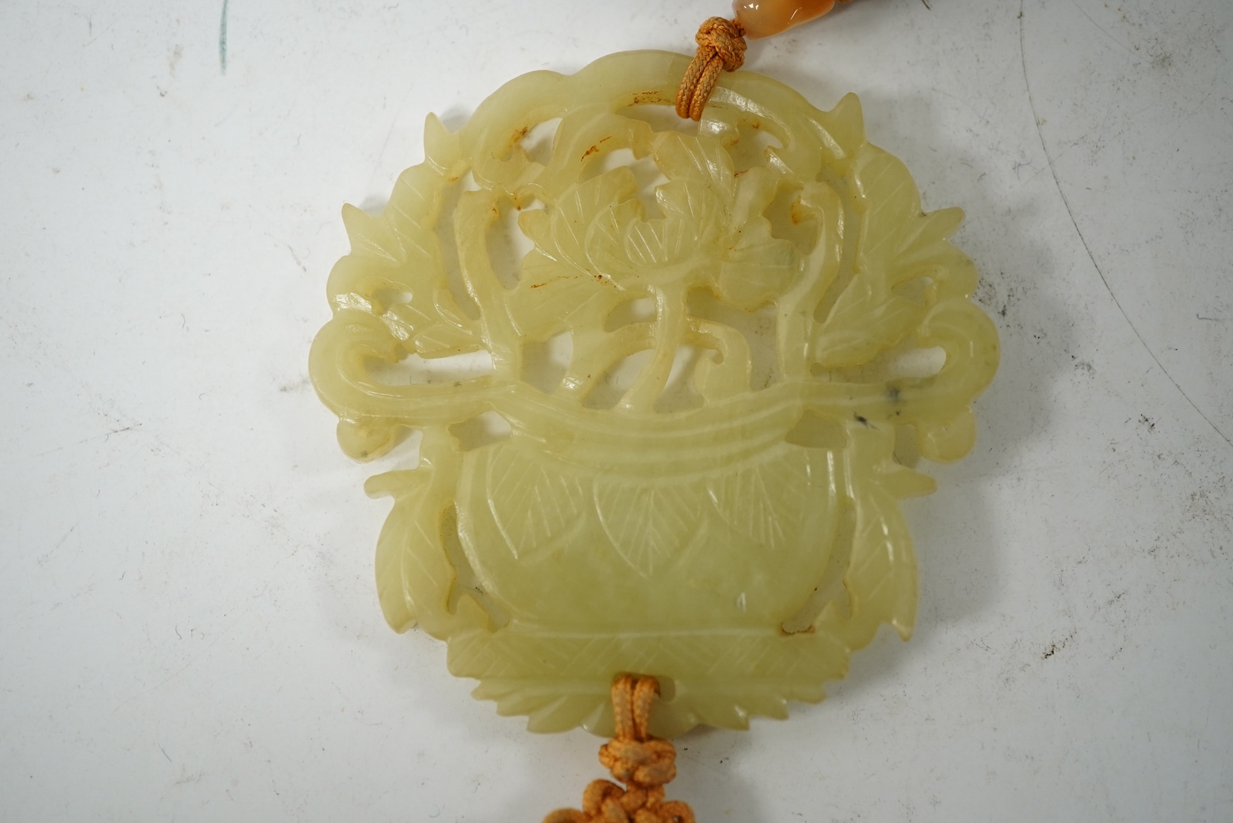 A Chinese pale celadon jade 'basket of flowers' pendant plaque, 19th century, 6cm wide. Condition - good